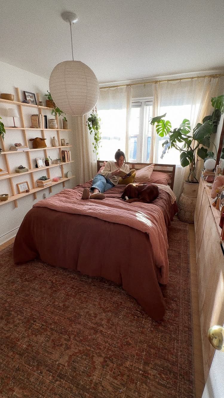 Patterned vintage rug on the floor of a cozy bedroom with plants and shelving.