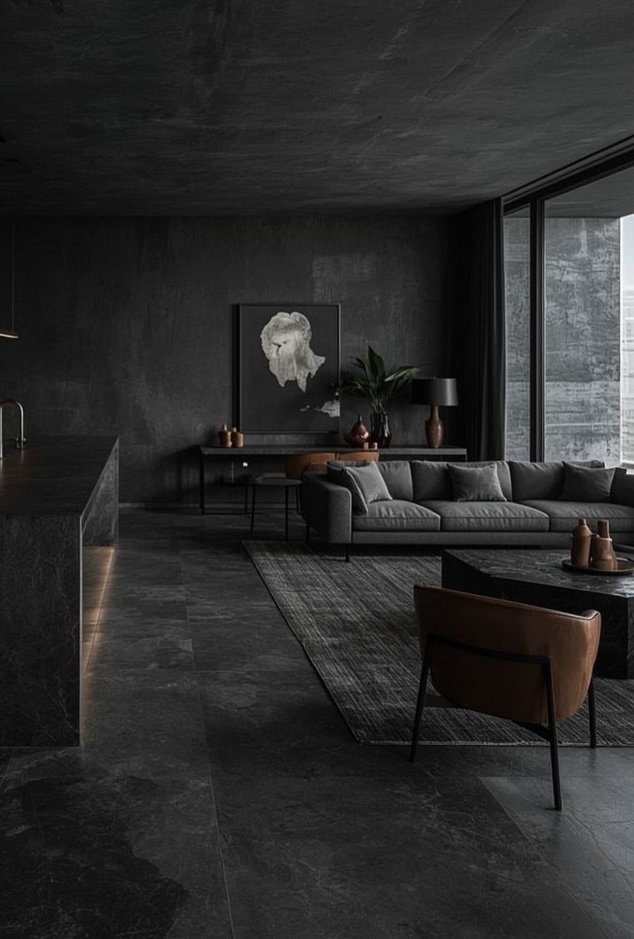 Dark concrete living room with grey sofa and brown leather accent chair