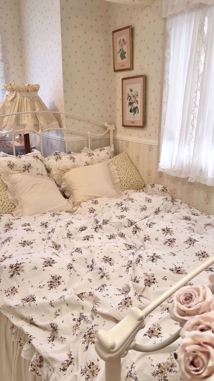 White metal bed with floral bedding and lace curtains in a vintage room.