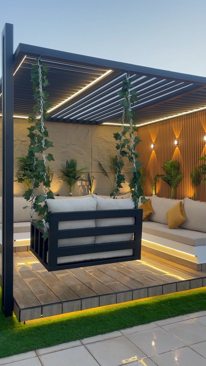 Modern outdoor lounge with warm ambient glow from under-bench and ceiling lighting.