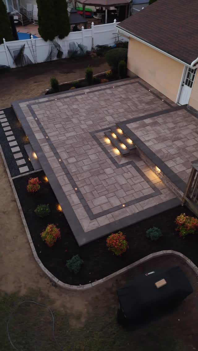 Stone patio with integrated hardscape lighting embedded in the borders and under steps.