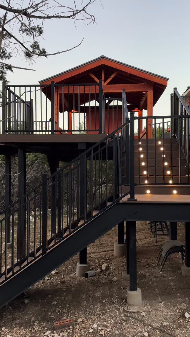 Wooden deck stairs and gazebo with small warm white lights along the steps