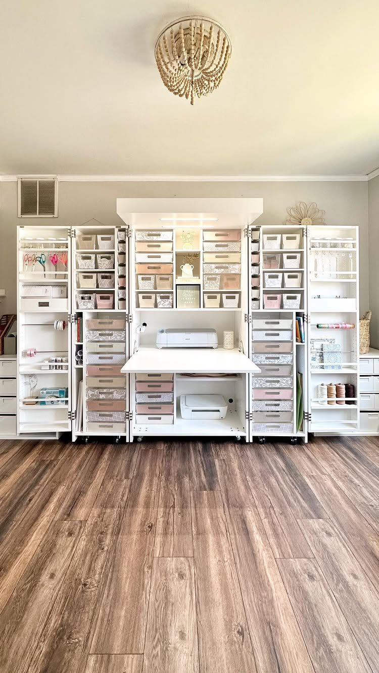 White craft room organization system with shelves, drawers, and bins on wood floor.