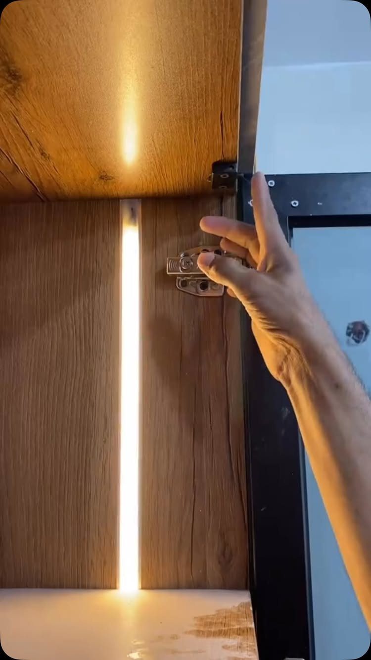 DIY LED Light Lamp Ideas: 27 Backlights, Pendants, Table Lamps 5 Vertical LED light strip glowing inside a wooden closet cabinet with a hand pointing.