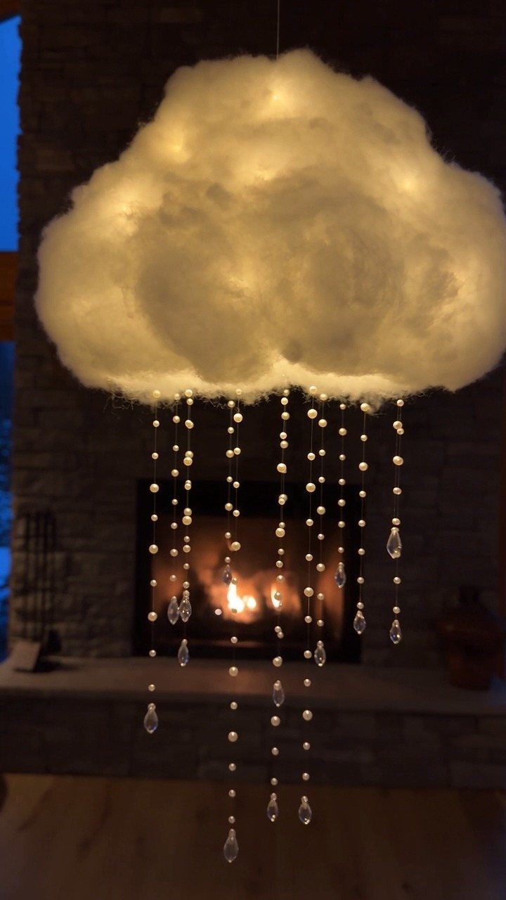 DIY LED Light Lamp Ideas: 27 Backlights, Pendants, Table Lamps 22 Cloud-shaped LED lamp with hanging crystal rain droplets in front of a fireplace.