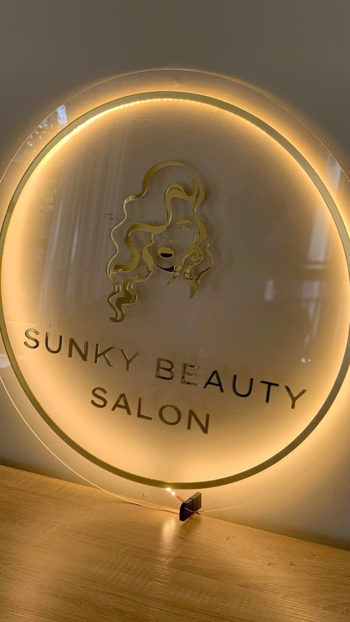 DIY LED Light Lamp Ideas: 27 Backlights, Pendants, Table Lamps 11 Circular acrylic beauty salon sign with warm yellow LED backlighting on wooden surface