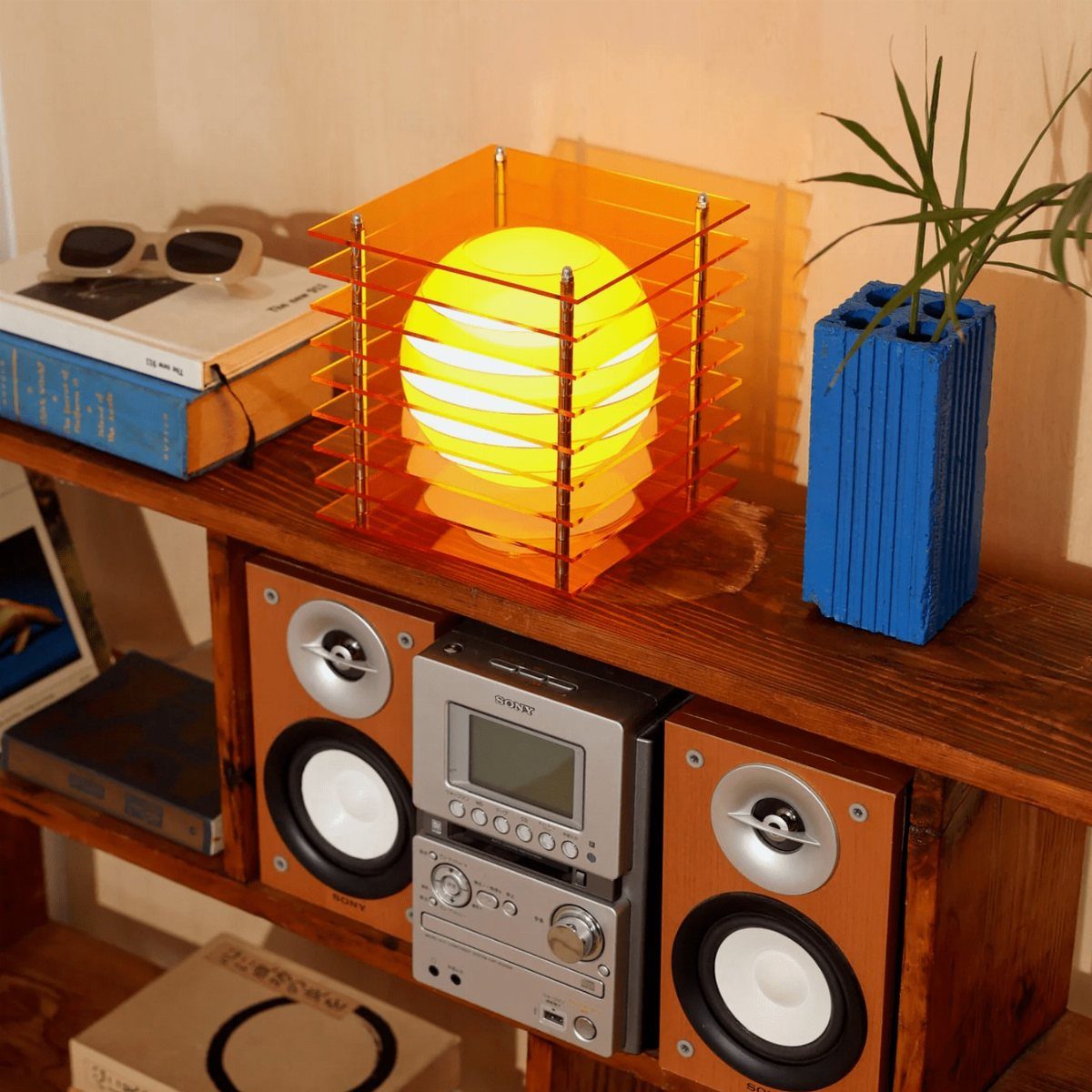 DIY LED Light Lamp Ideas: 27 Backlights, Pendants, Table Lamps 10 Square orange acrylic LED lamp with a glowing yellow sphere on a wooden shelf.
