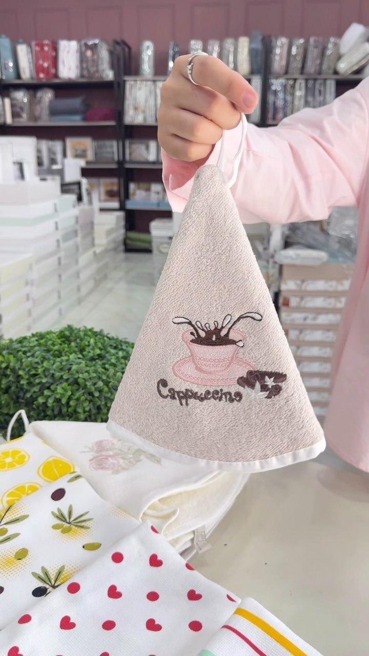 Beige linen kitchen towel with embroidered coffee cup and cappuccino text.