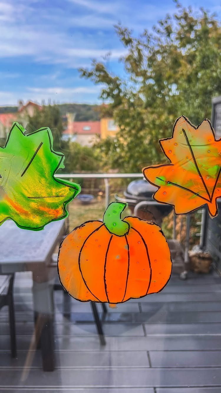 Autumn gel window stickers of a pumpkin and leaves on a glass door.