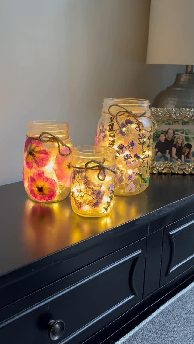 Mason jars with dried flowers and fairy lights tied with twine on a dresser