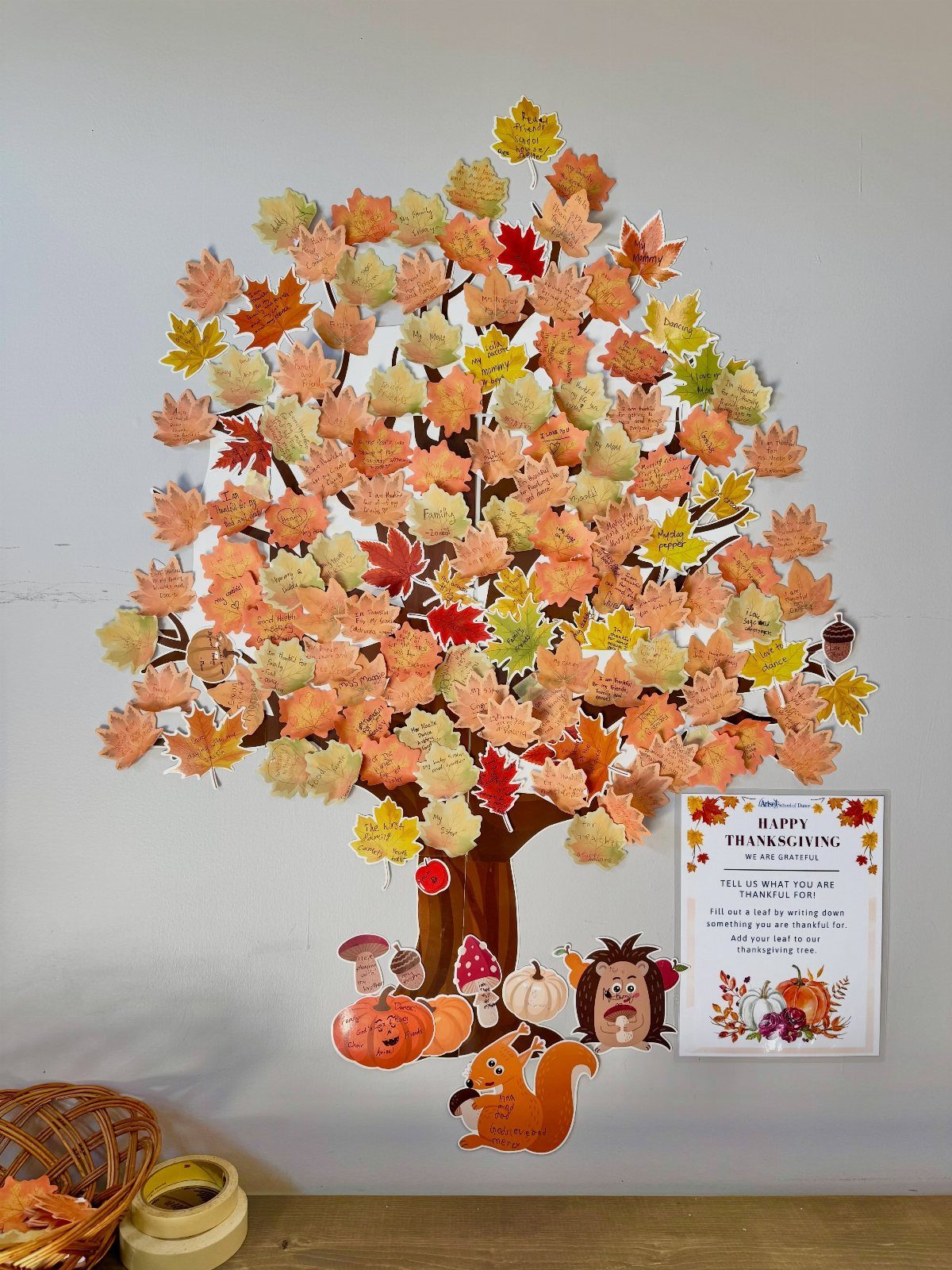 Autumn leaf tree wall decoration with paper pumpkins and a Thanksgiving sign.