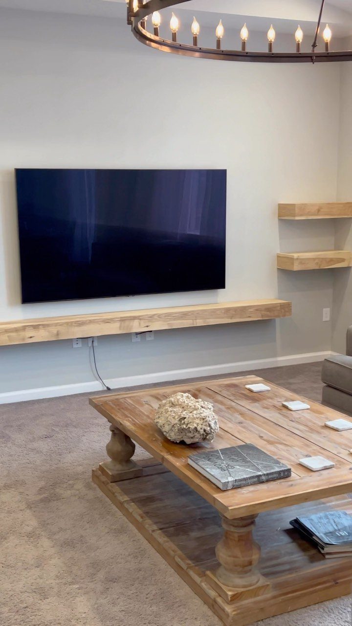 Floating Shelf Under TV Ideas: 31 Styles for Living Rooms 1 Wall-mounted TV with a long light wood floating shelf and side shelves.