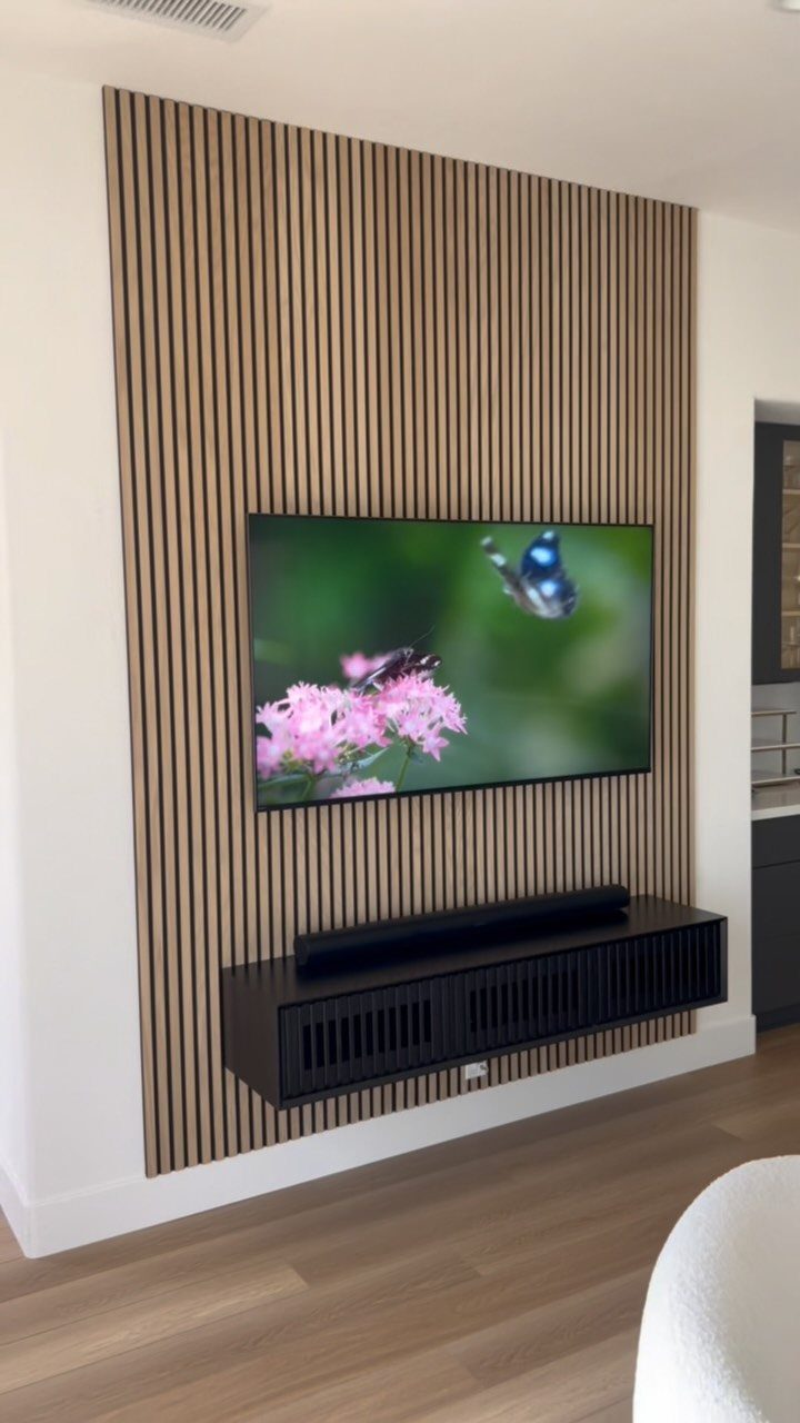 Floating Shelf Under TV Ideas: 31 Styles for Living Rooms 27 TV mounted on a vertical wood slat accent wall with a black floating console