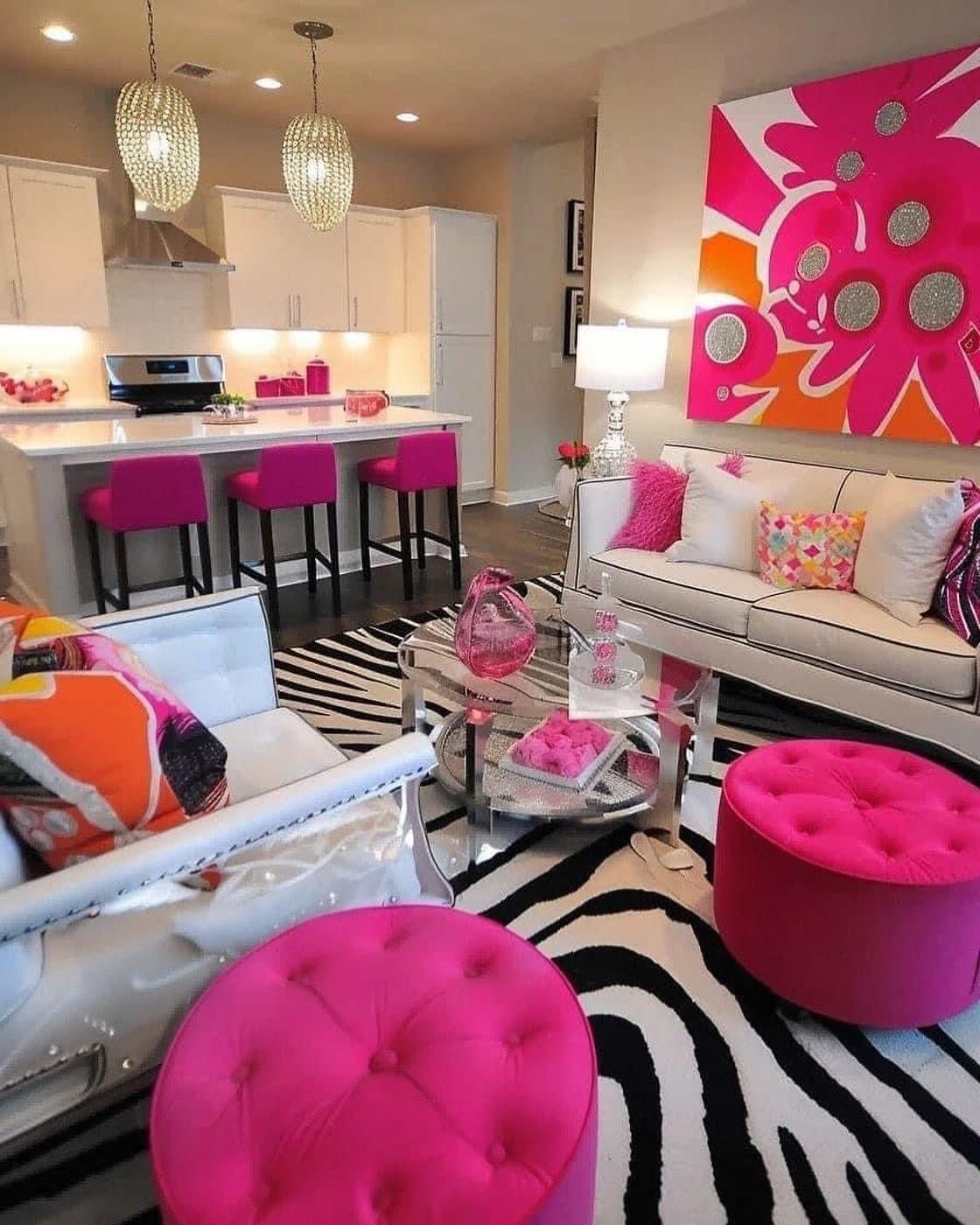 Glamorous living room with pink ottomans, zebra rug, and large pink floral art.