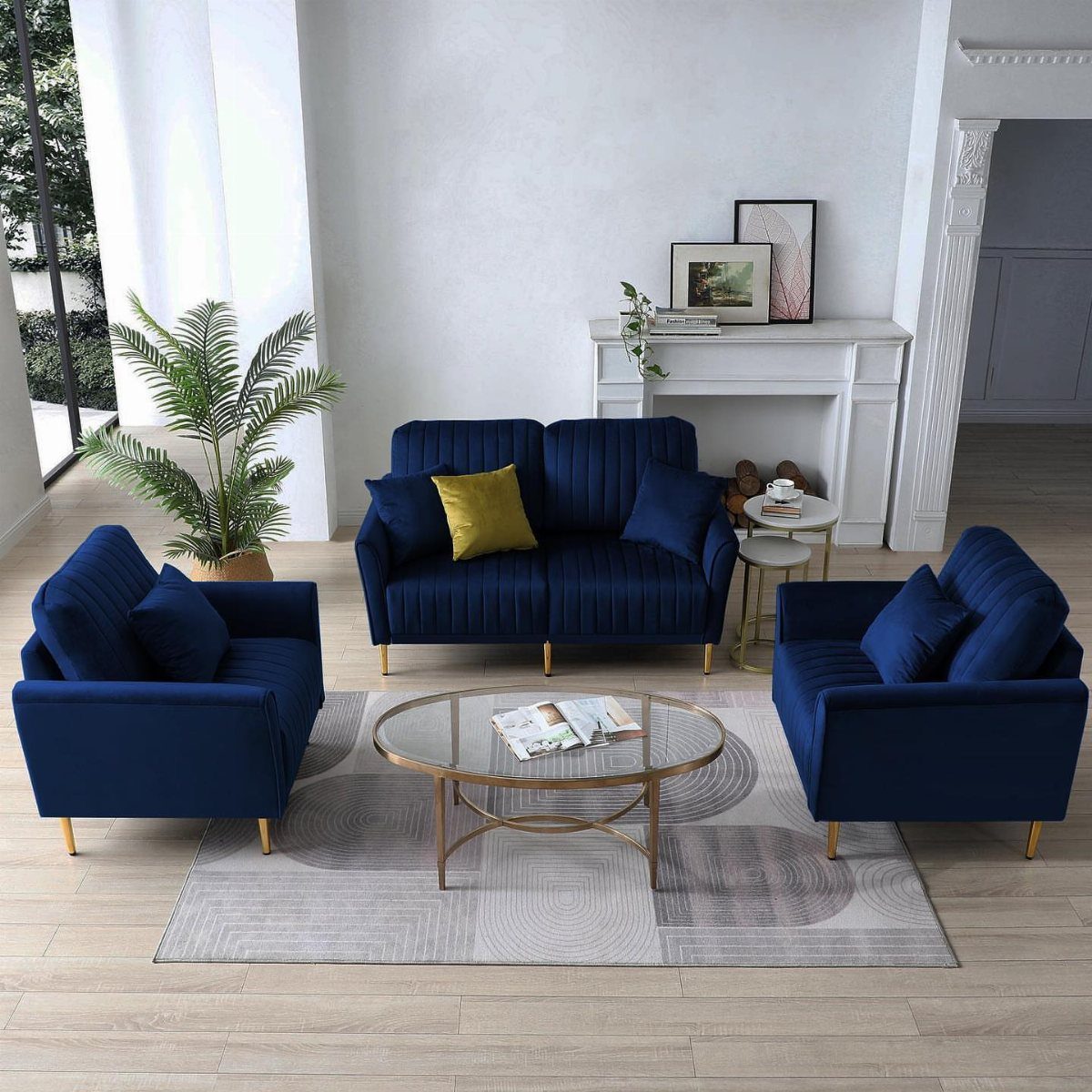 Navy blue velvet sofa and armchairs with gold legs in a bright living room.