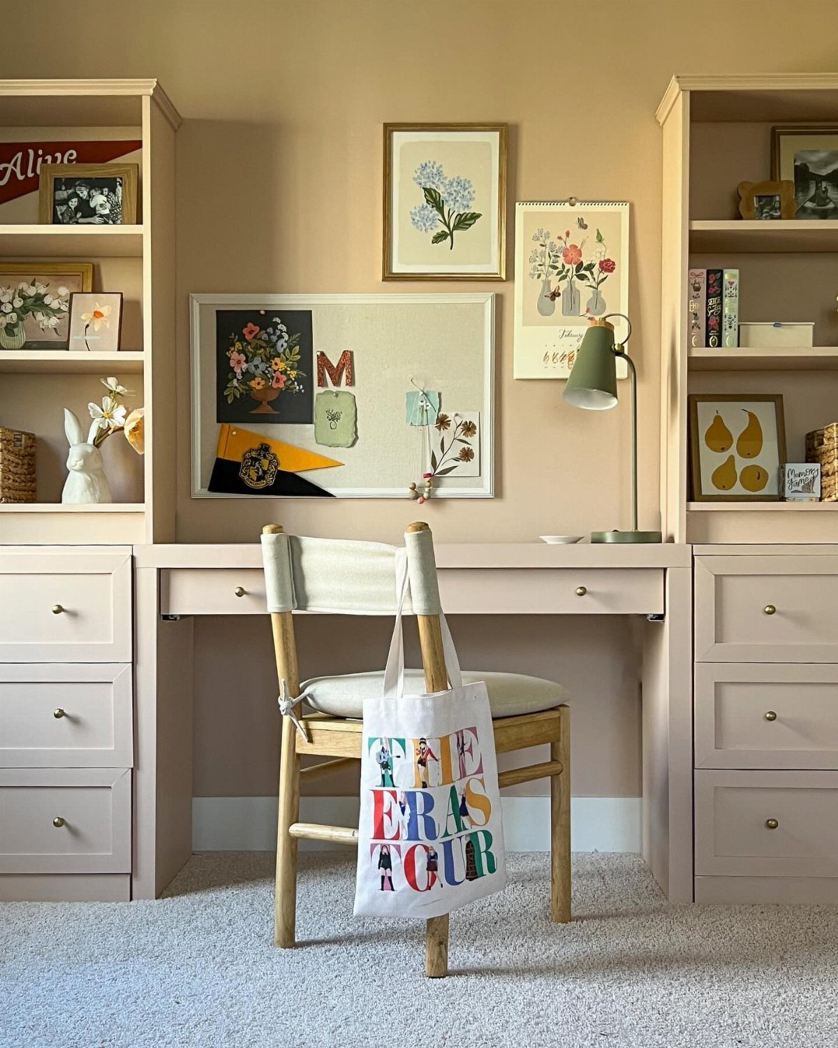Light pink desk flanked by two matching bookcases with drawers in a home office.