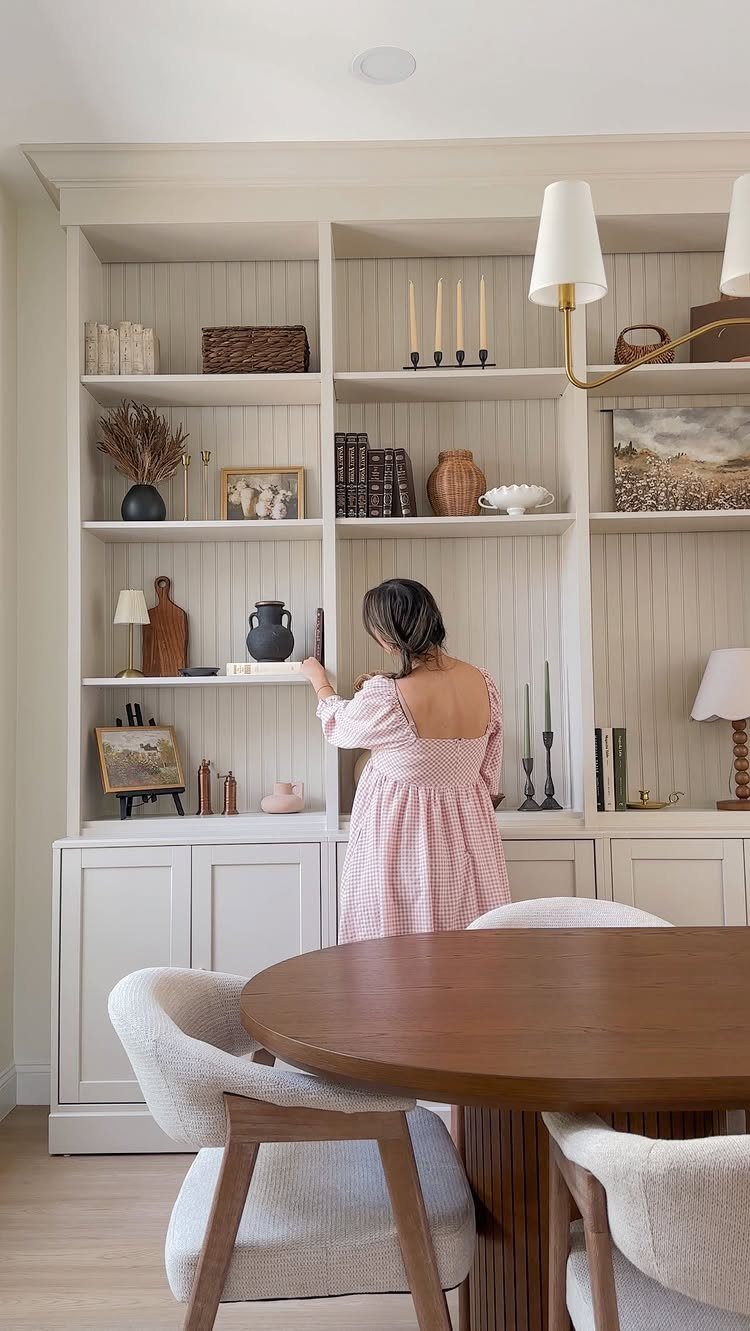White built-in wall library with shelving and cabinets in a bright dining room