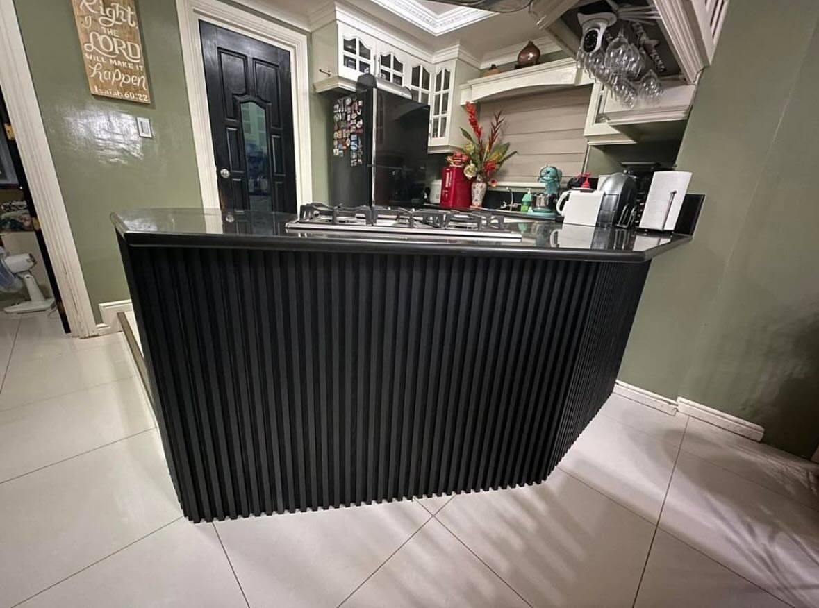 13 Kitchen Island Back Panel Ideas, From Beadboard to Stone 5 Black kitchen island with a fluted back panel and dark stone countertop.