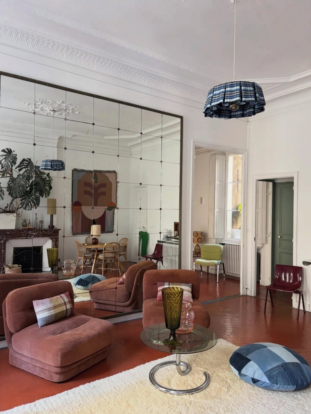 Wall-to-wall living room mirror with incised gridlines reflecting a modern seating area.