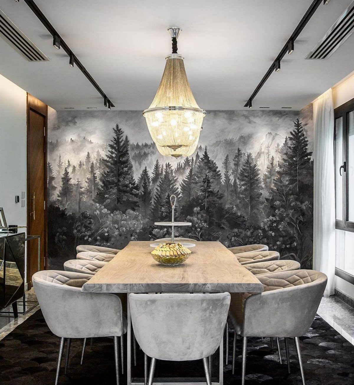 Lights for Room Decoration: 12 Ideas for Every Style in 2026 2 Ornate crystal chandelier hanging over a wooden dining table with forest mural wallpaper.