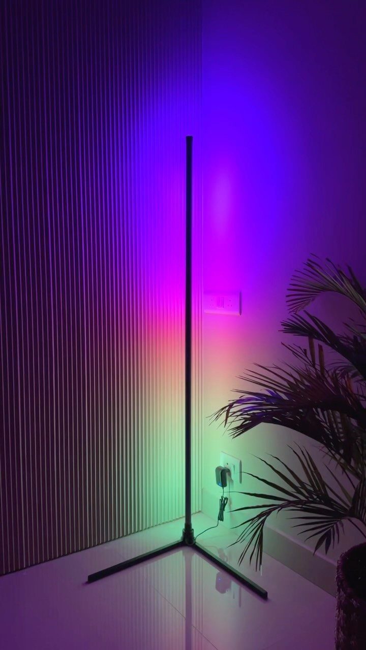 Lights for Room Decoration: 12 Ideas for Every Style in 2026 11 Sleek black corner floor lamp casting colorful purple and green light in a room.