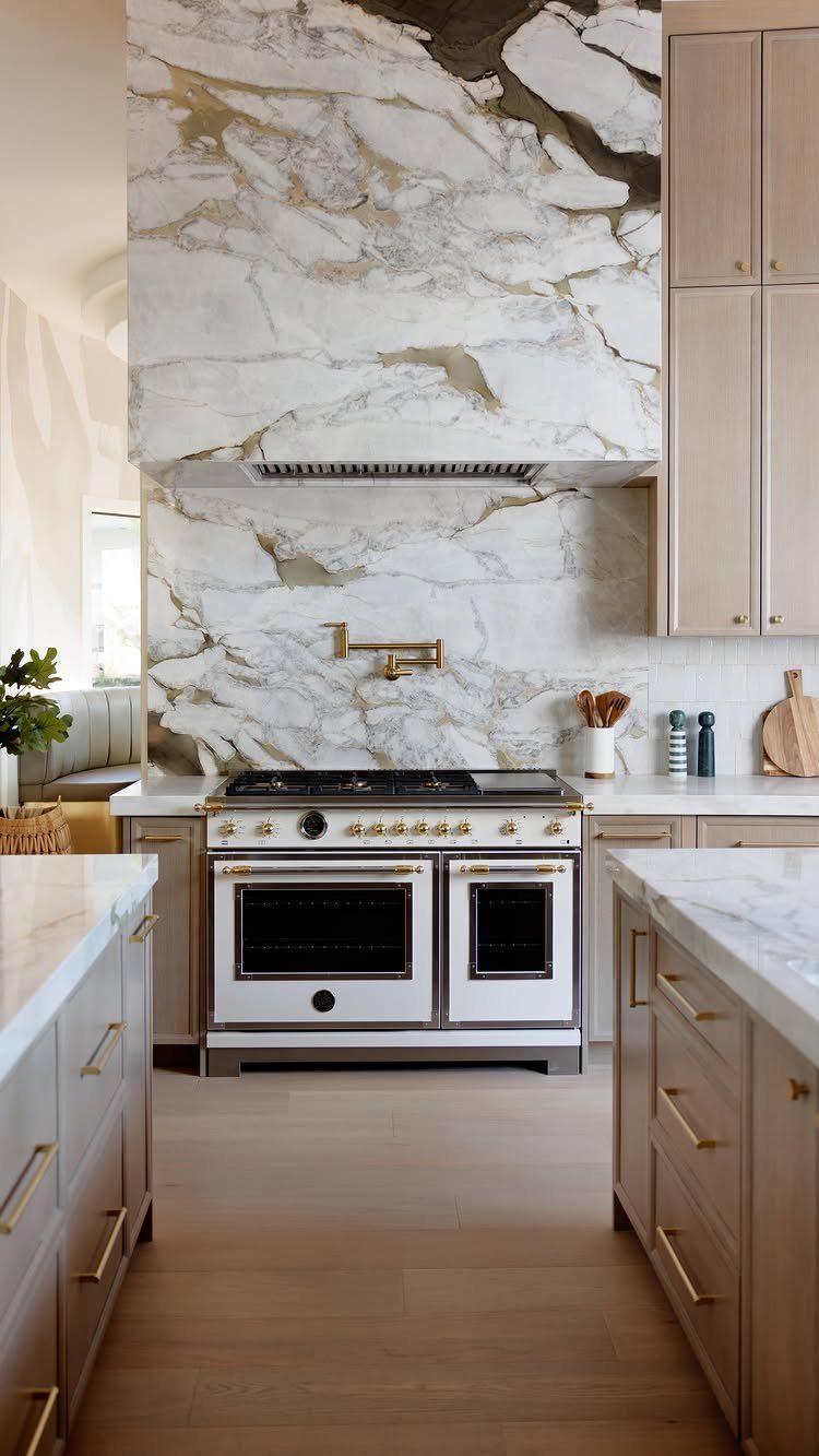 Modern Kitchen Hood Ideas: 12 Designs from Metal to Minimalist 10 Marbled stone range hood extending to the ceiling above a professional stainless steel stove.