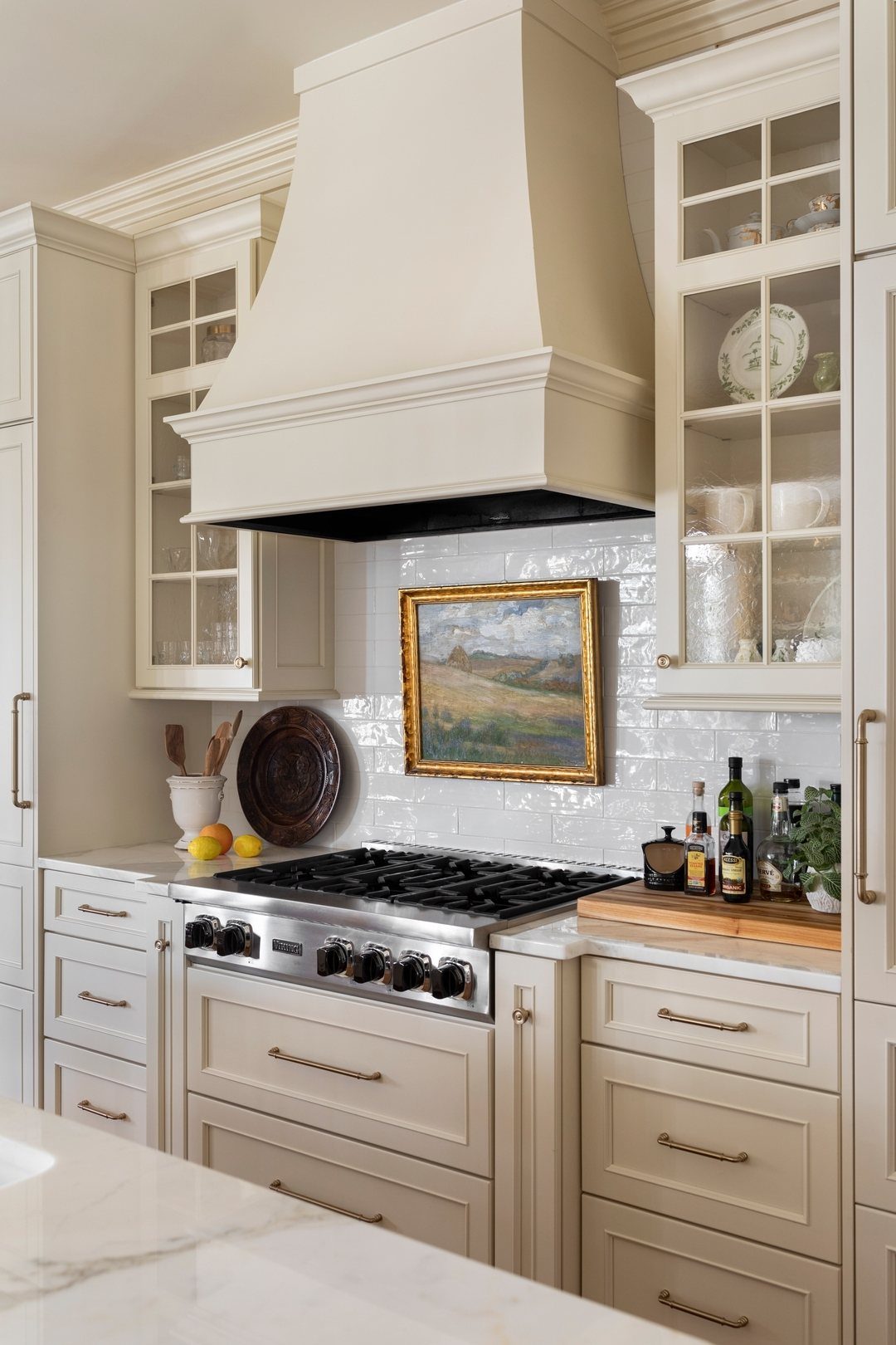 Modern Kitchen Hood Ideas: 12 Designs from Metal to Minimalist 5 Cream-colored custom range hood above a gas stove in a bright white kitchen.