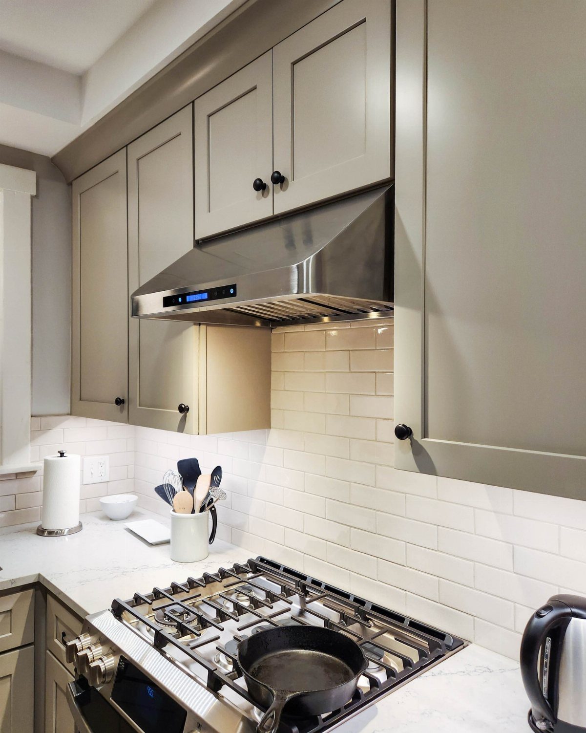 Modern Kitchen Hood Ideas: 12 Designs from Metal to Minimalist 3 Stainless steel under-cabinet range hood above a gas stove with white subway tiles.