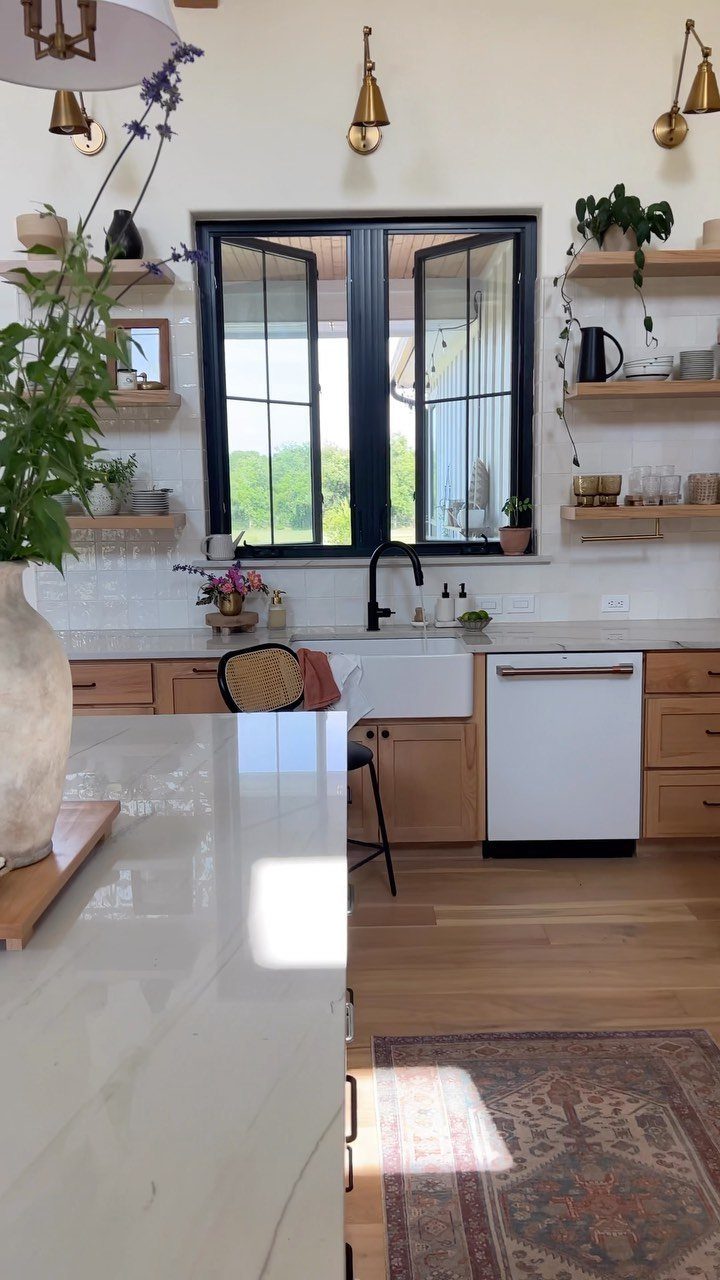 Wooden open shelves and lower cabinets in a bright kitchen with a window.