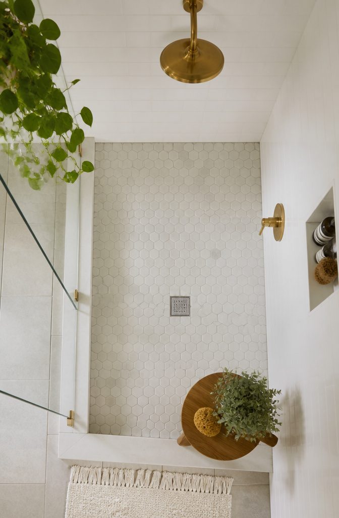 A shower featuring basic white subway tiles.