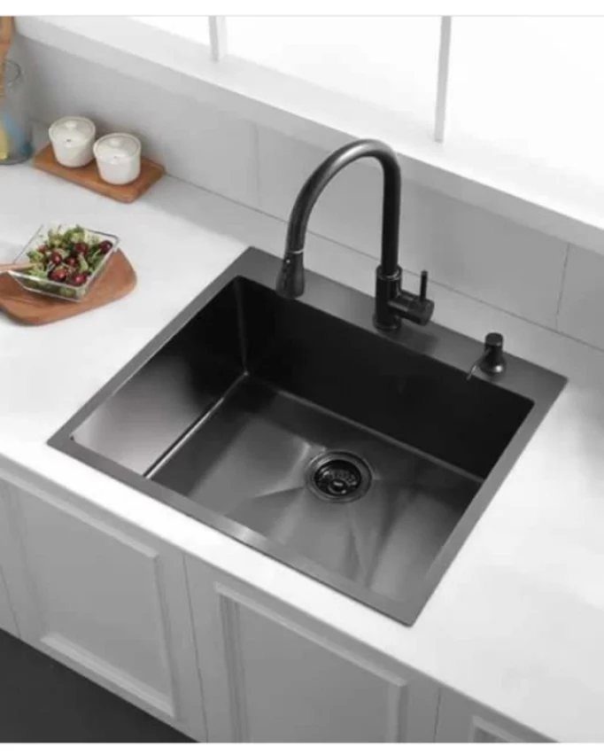 Black undermount kitchen sink with a black faucet installed in a white countertop.