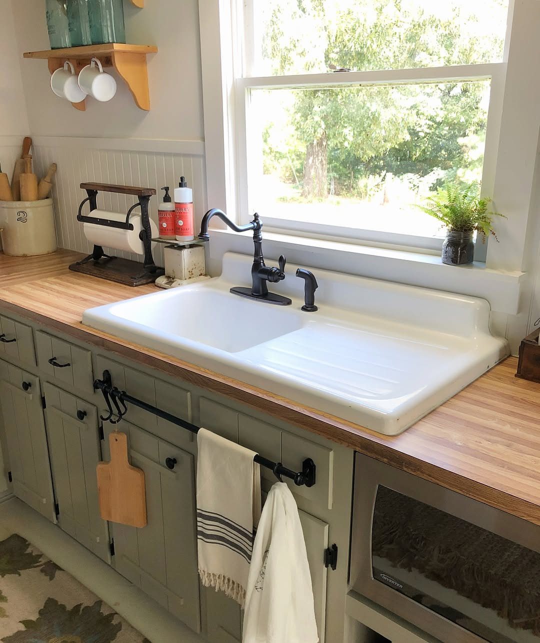 White porcelain sink with integrated drainboard on a light wood kitchen countertop.