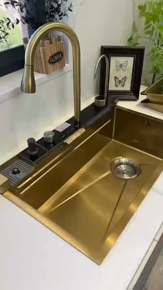 Gold kitchen sink with a matching high-arc faucet installed in a white countertop