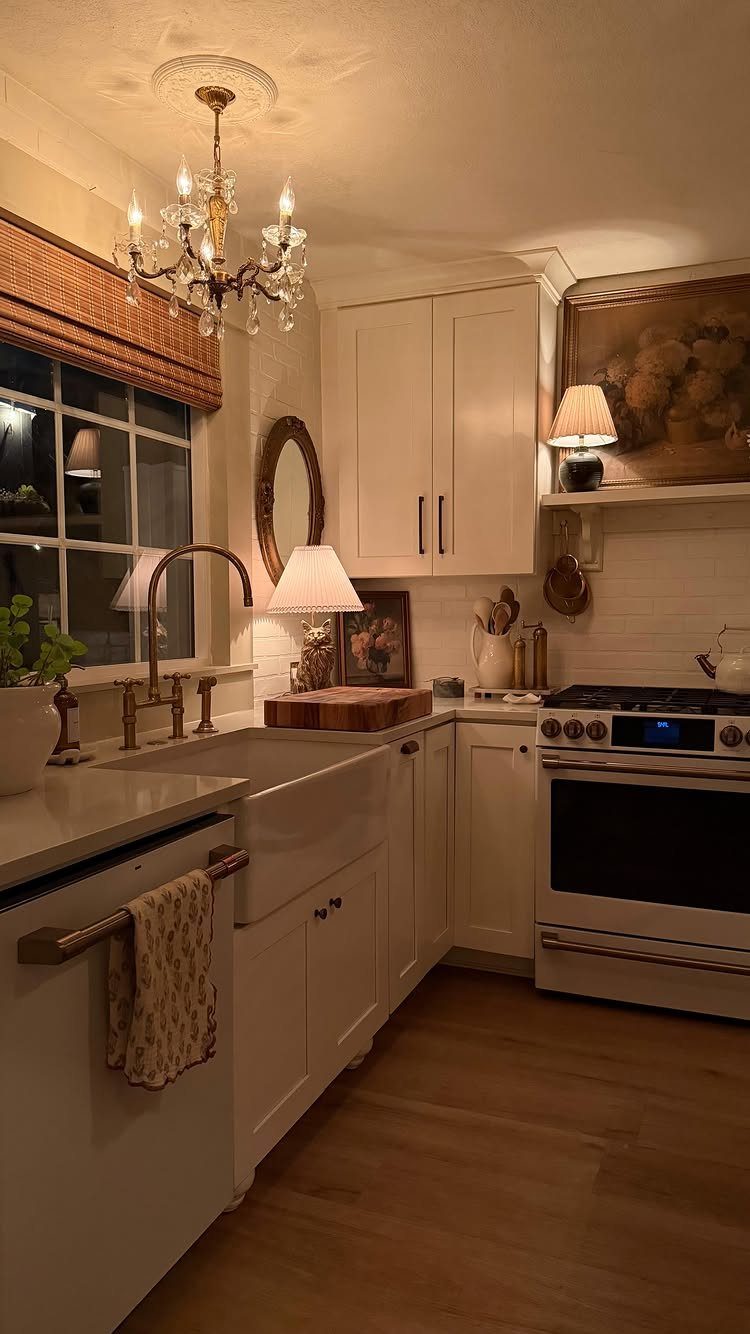 Small kitchen with white cabinets, farmhouse sink, and a crystal chandelier ceiling light.