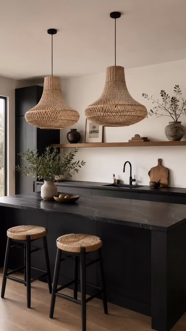 Two woven wicker pendant lights hanging over a black kitchen island with stools