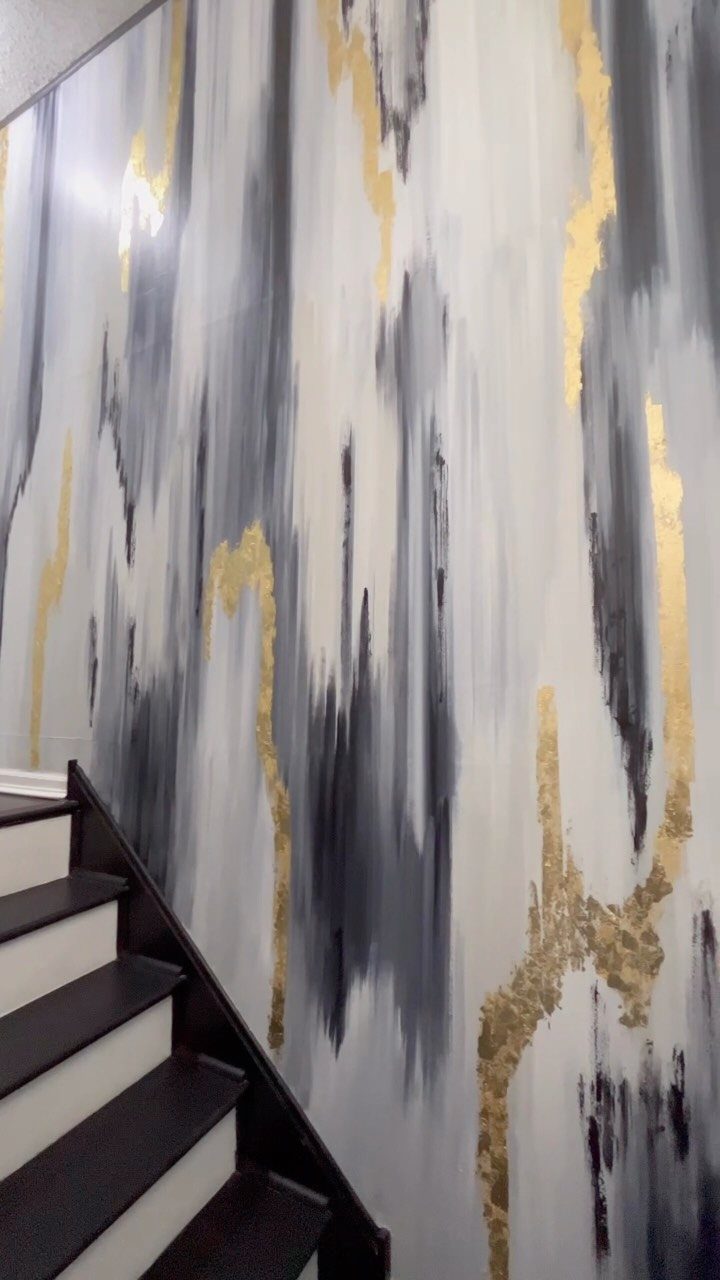 Abstract grey and gold metallic wallpaper accent wall in a modern stairwell