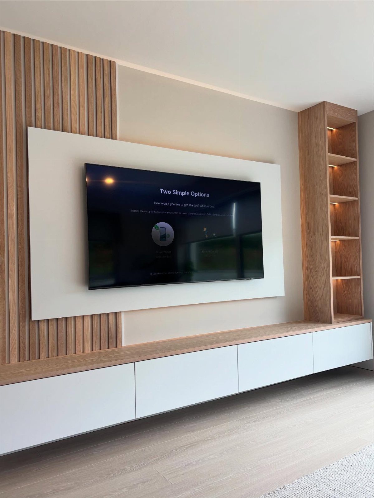 39 TV Design Ideas, from Built-In Shelving to Fireplace Walls 14 Floating white drawer stand with wooden top under a wall-mounted television and bookshelf.