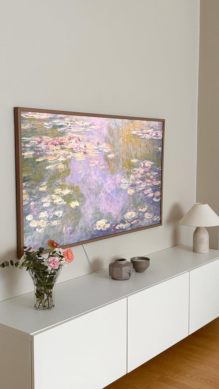 39 TV Design Ideas, from Built-In Shelving to Fireplace Walls 7 Frame TV displaying water lily art above a white floating console and lamp.