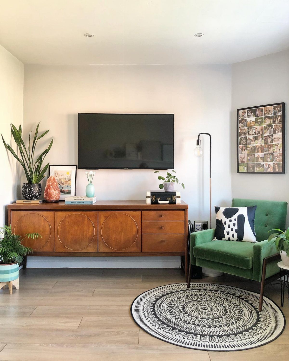39 TV Design Ideas, from Built-In Shelving to Fireplace Walls 4 Wall-mounted TV above a wooden mid-century sideboard in a bright living room setting.