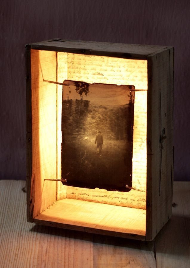 Wooden box lamp illuminating a vintage photograph inside a rectangular frame.