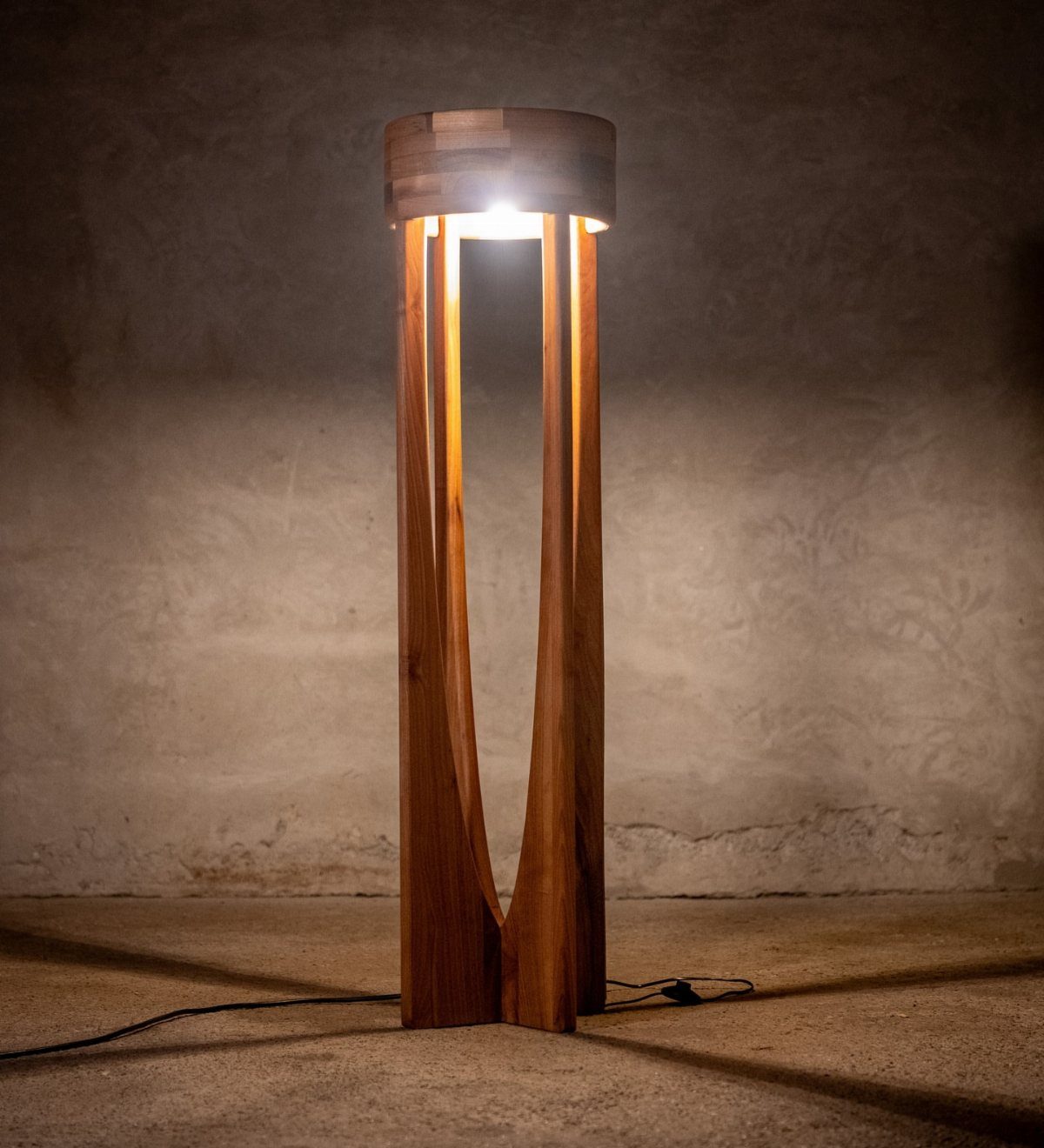Tall wooden floor lamp with a cylindrical shade and curved vertical supports.