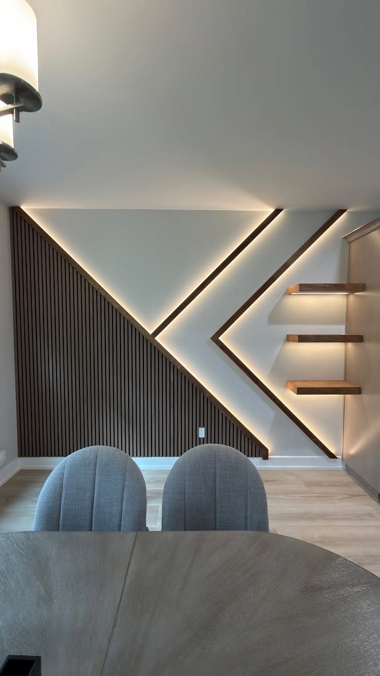 Wood Slat Wall with Shelves: 10 Ideas for Plants, TVs, Desks 10 Wood slat wall with diagonal lighting and floating wooden shelves in a modern room.